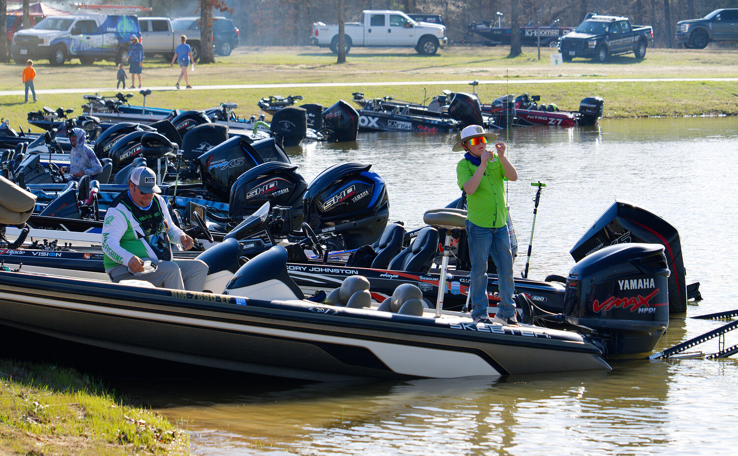 A young angler switches bait on one of the competition bass boats.